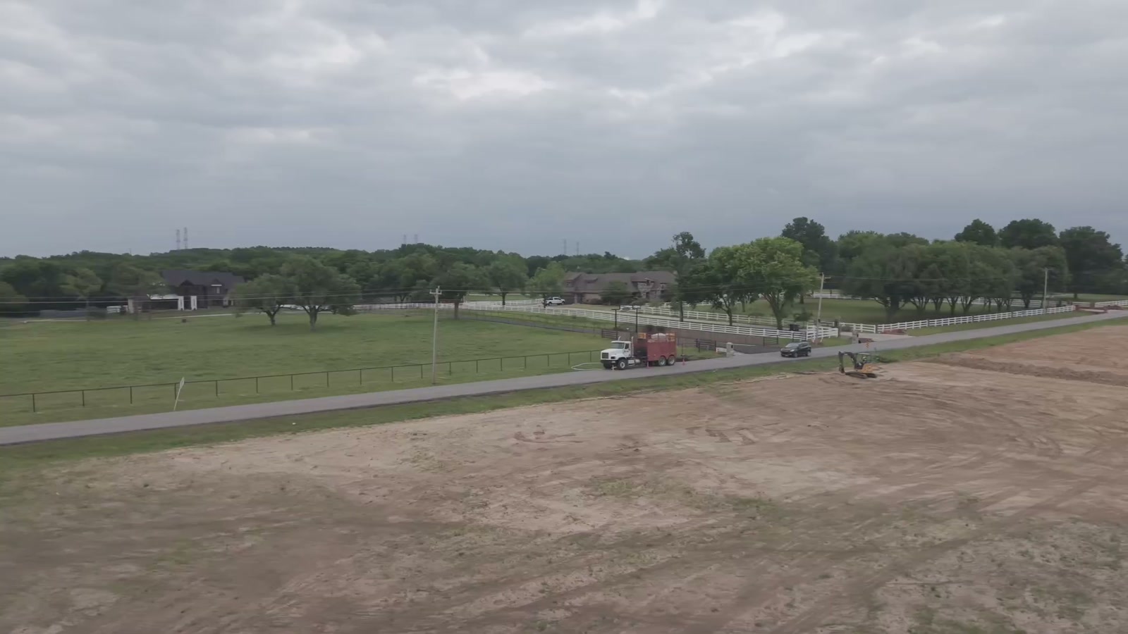 Aerial view of an acreage property with fences and open land